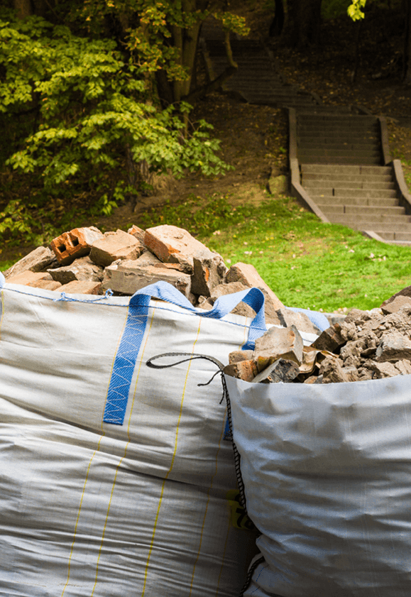 Custom construction bags in a garden full of building rubble